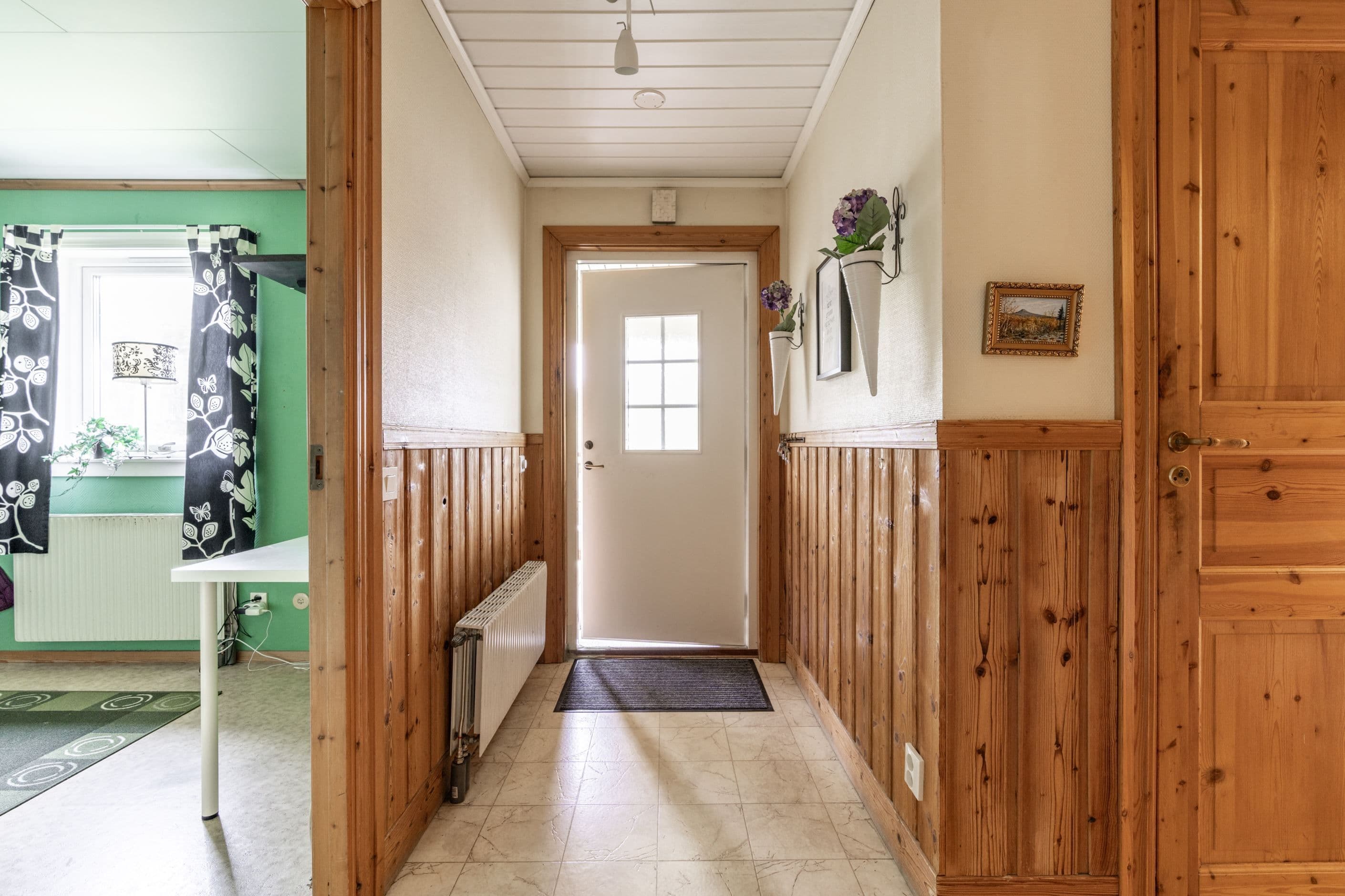 Hall med sovrum 1 till vänster i bild och dörr till badrum till höger