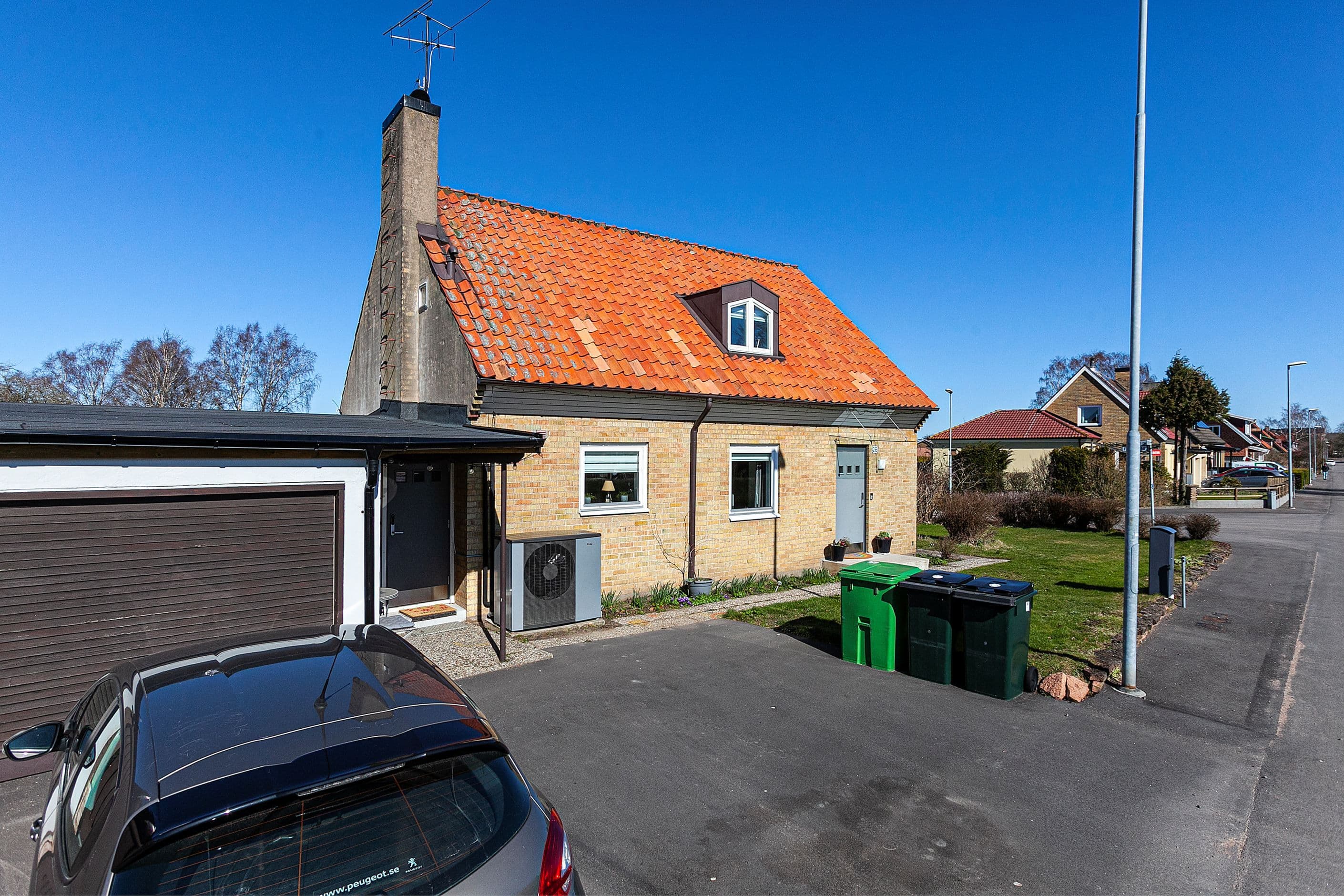 Fasad med huvudentré och garage