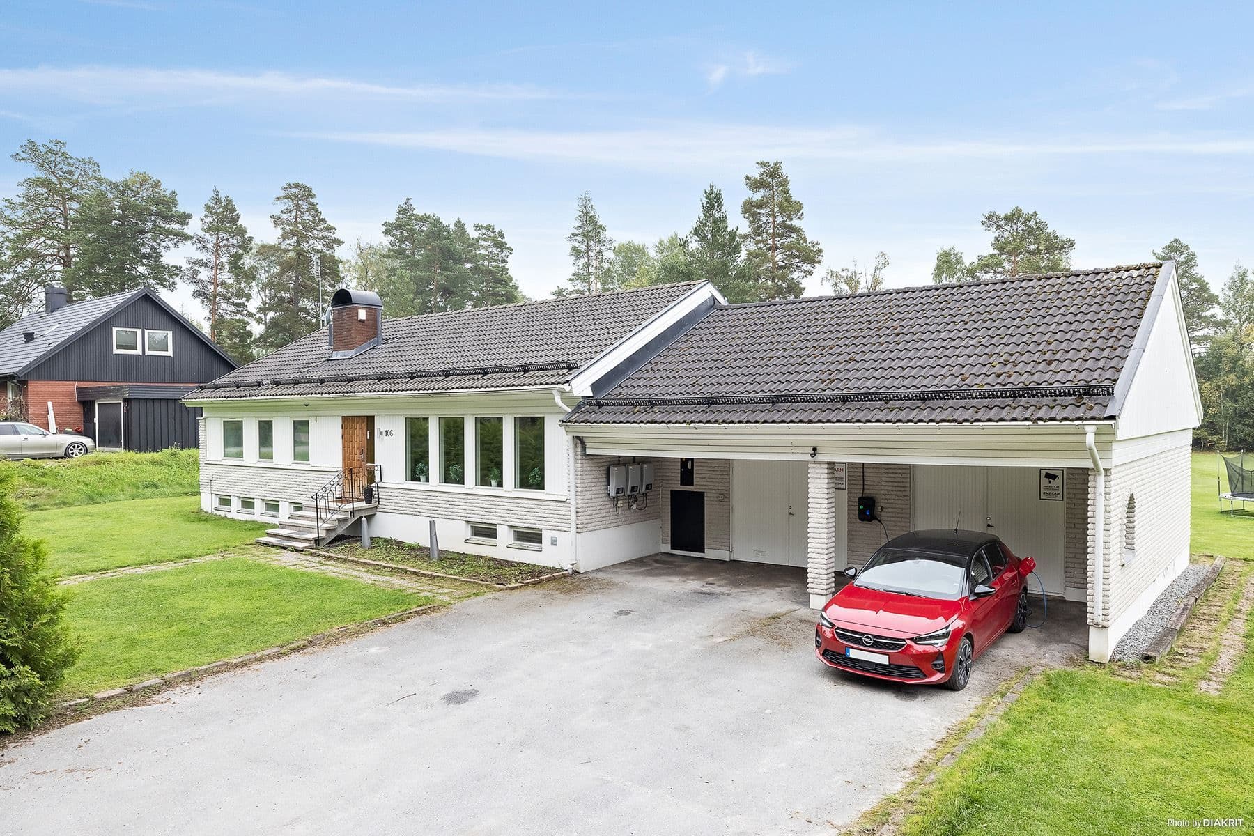 Entrésidan med uppfart och garage