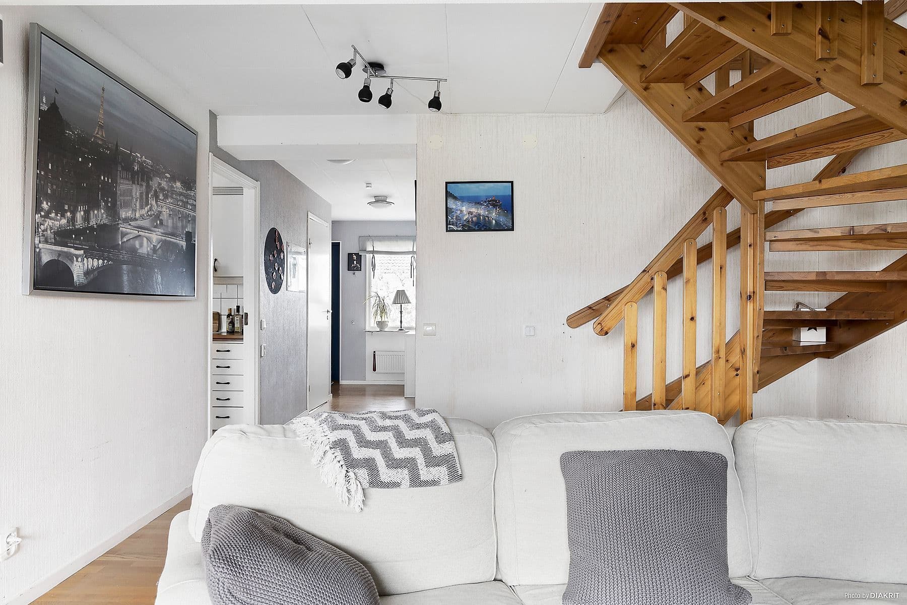 Del av vardagsrum med blick mot hall och entré