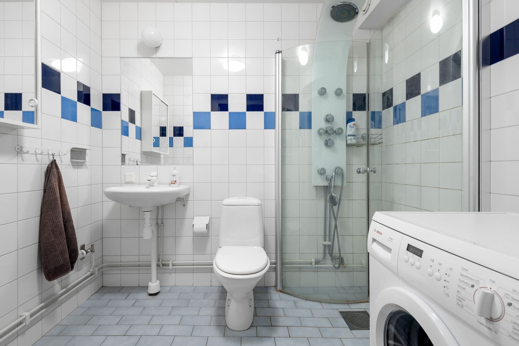 Kaklat badrum med duschhörna och egen tvättmaskin