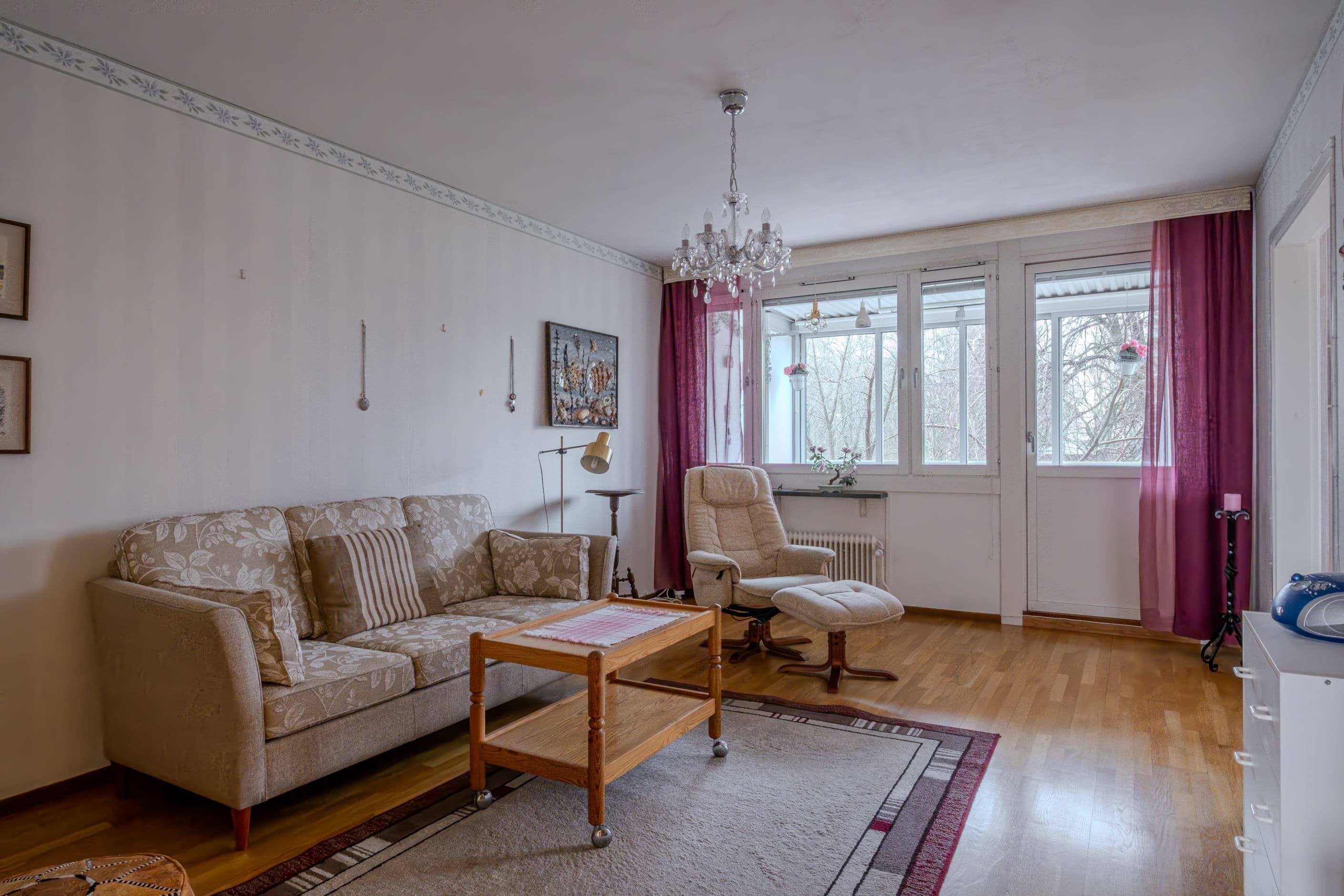 Vältilltaget vardagsrum med utgång till bostadens balkong
