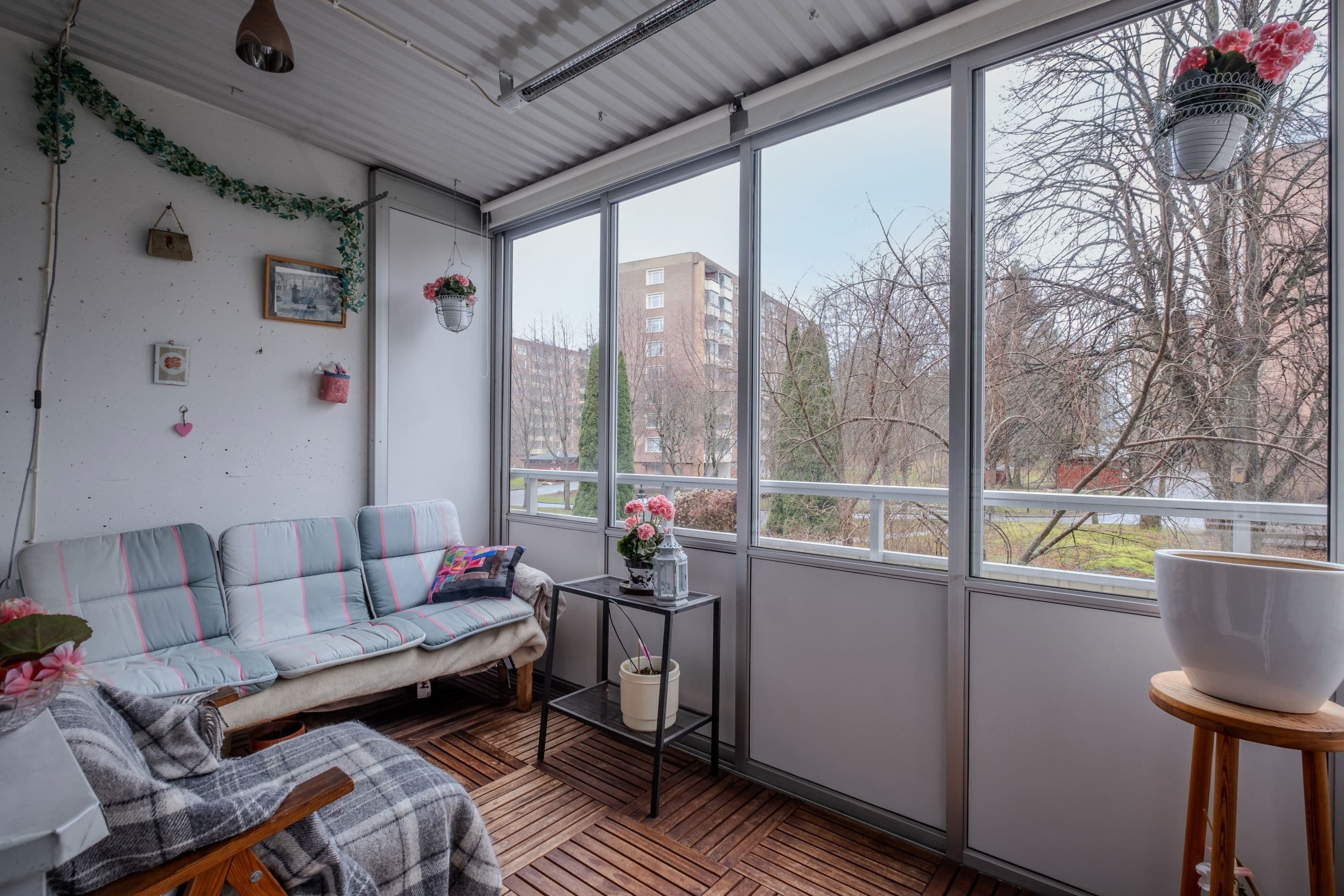 Stor inglasad balkong med trätrall och söderläge