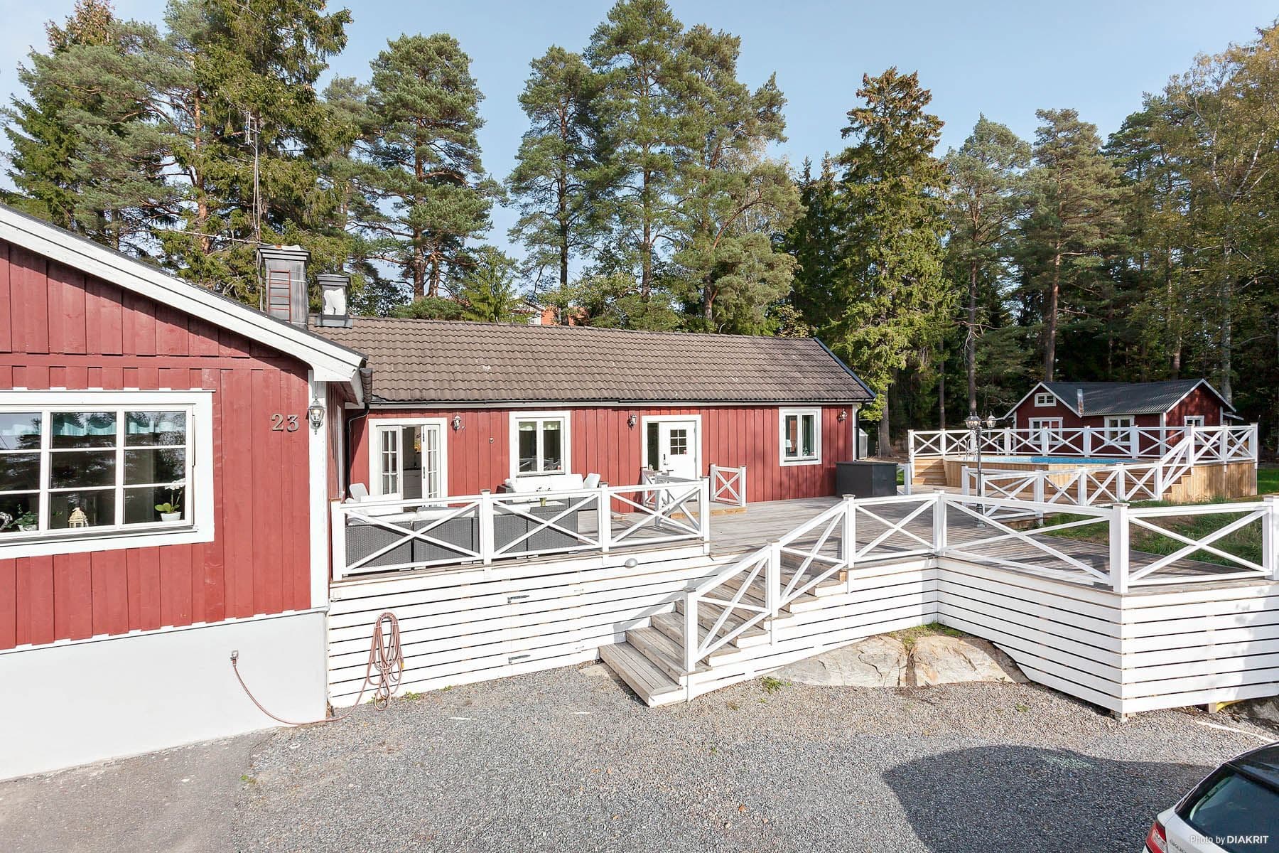 Enplansvilla i vinkel med stor altan, pool, garage och grusad uppfart