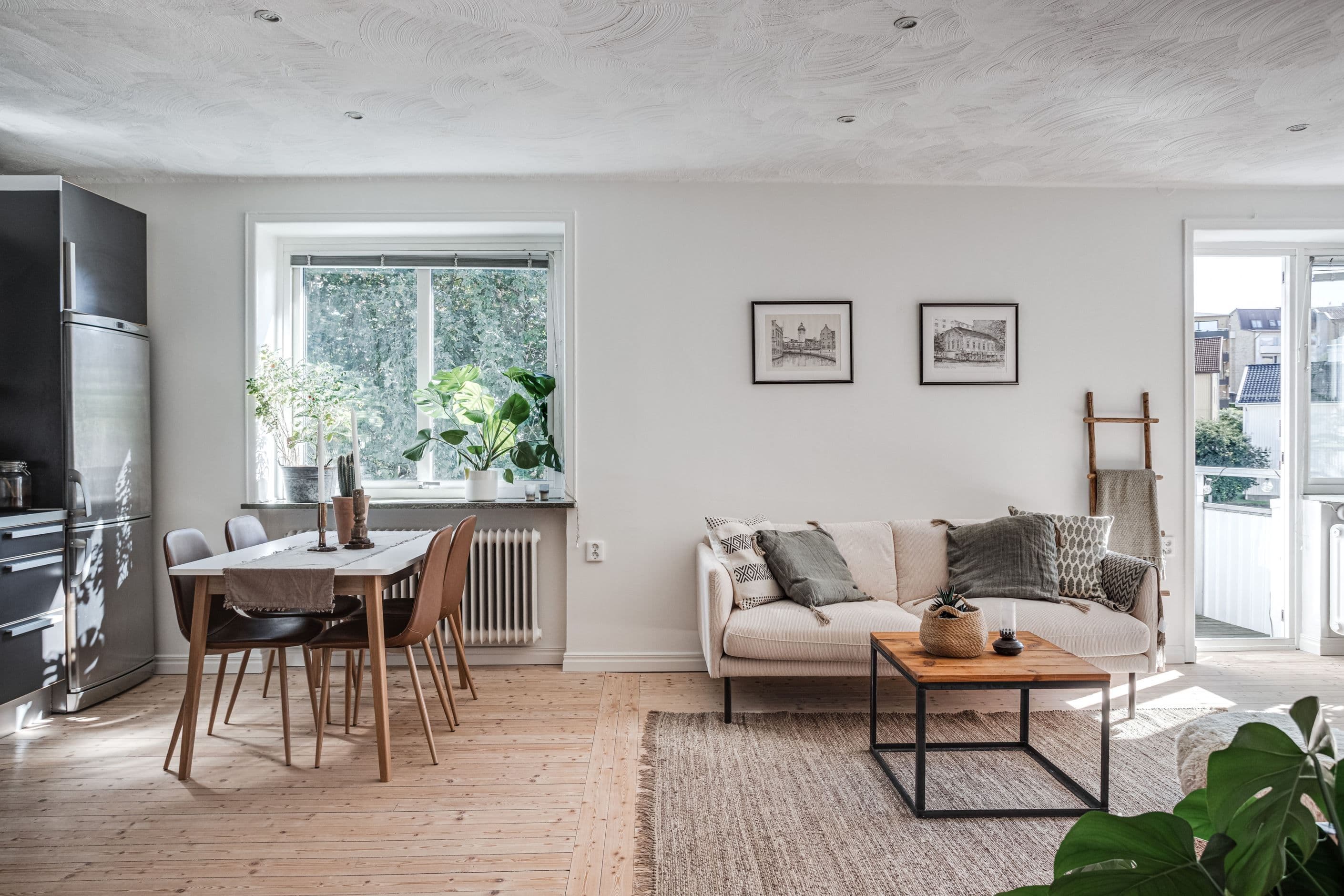 Vardagsrummet ligger i en öppen planlösning mot köket med fönster och ljus in från två riktningar