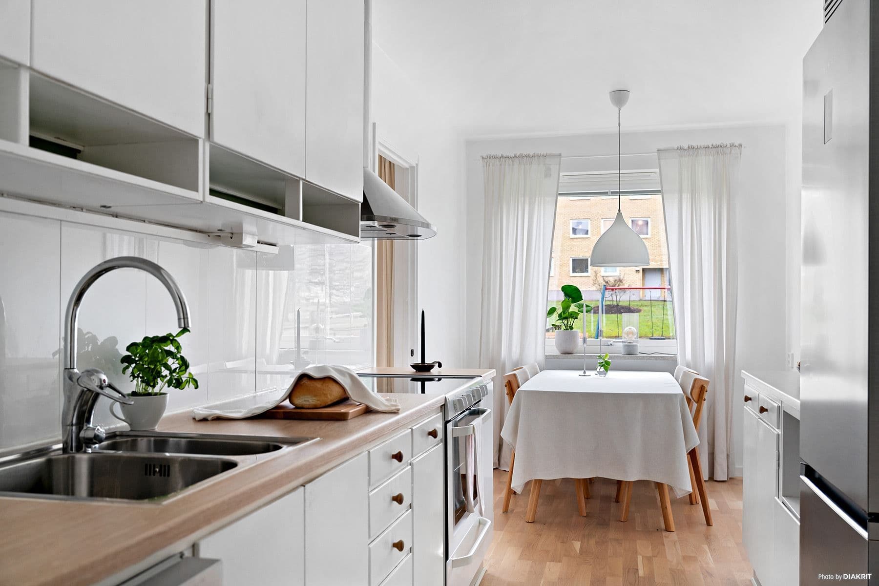 Ljust kök med plats för matbord intill fönstret