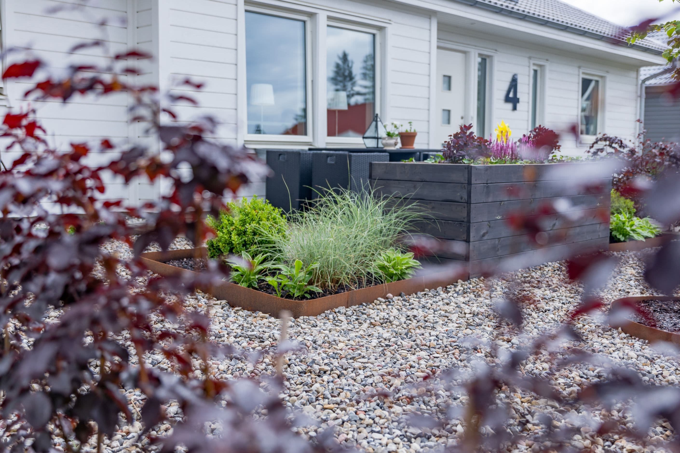 Genomtänkt trädgård med prydliga stensättningar och planteringar