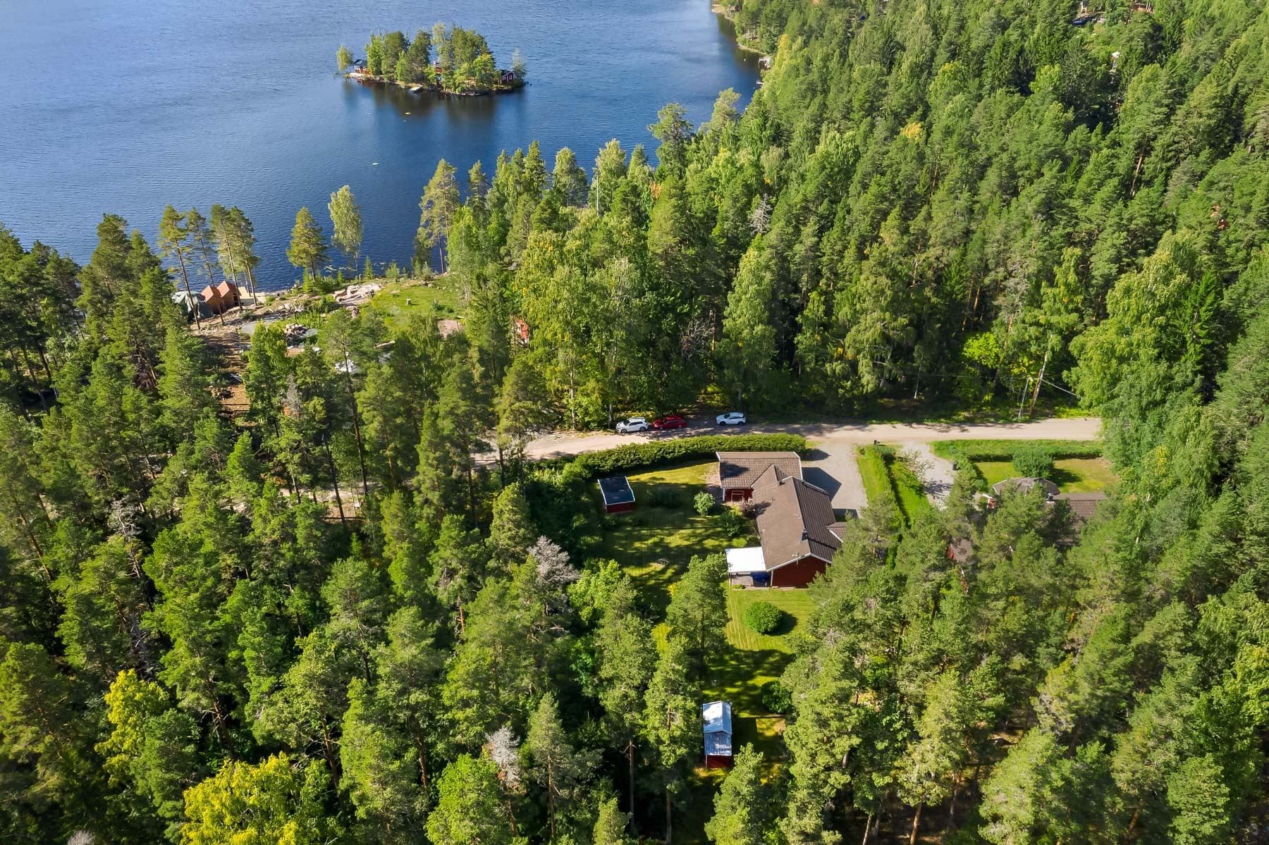 Vy över fastigheten med sjön Stora Vällan i bakgrunden
