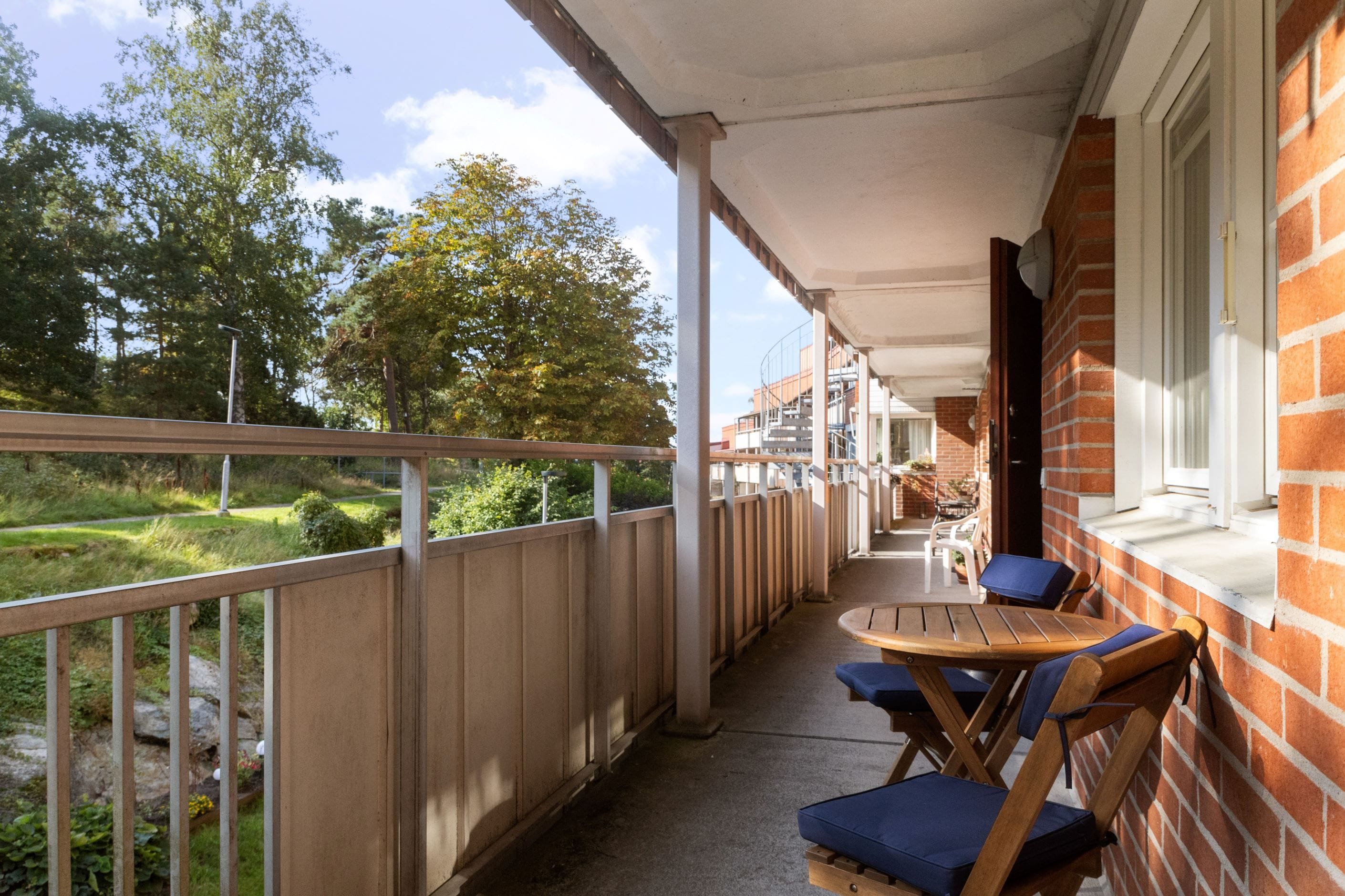 Loftgång med plats för cafébord i morgonsolen.