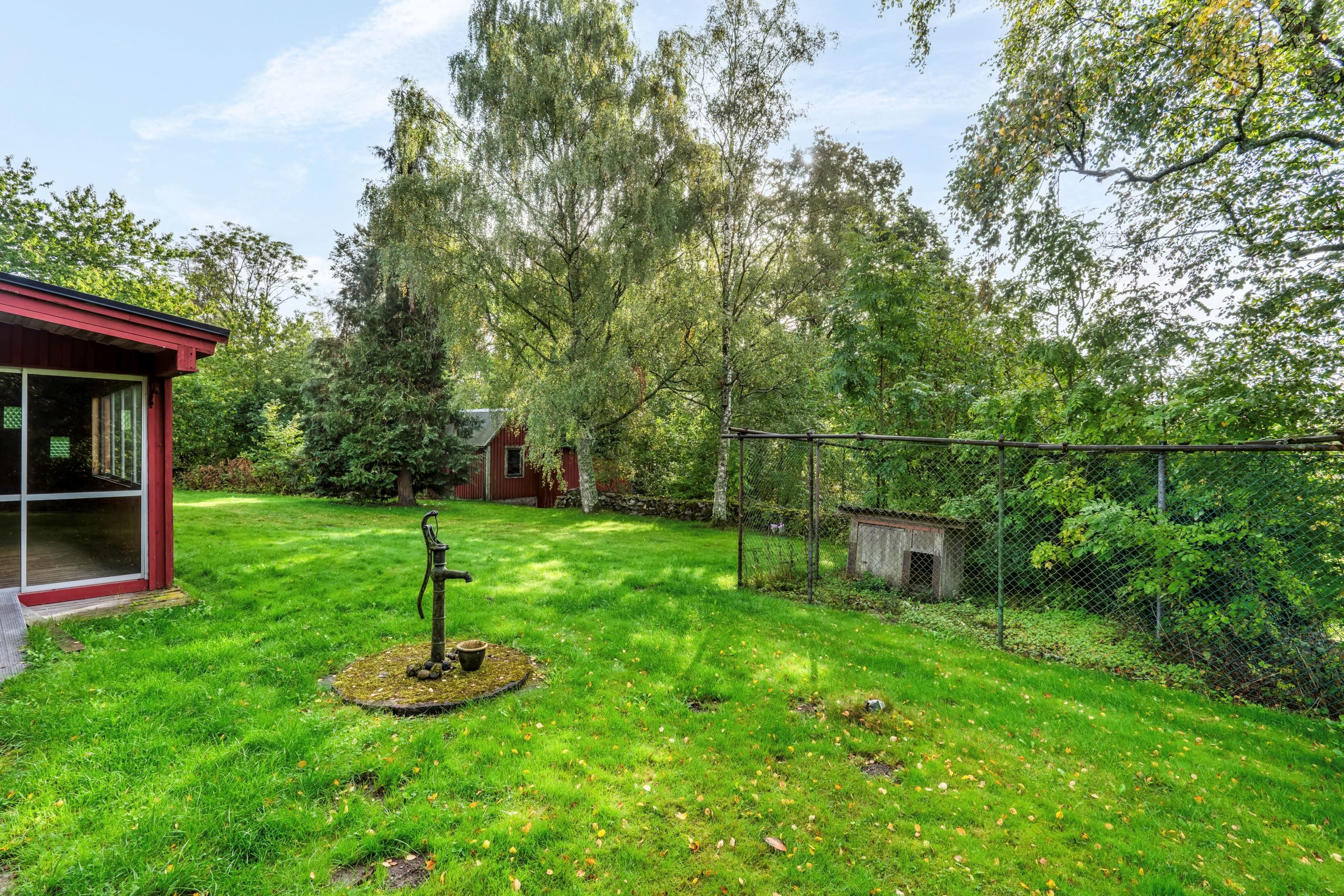 Lummig tomt omgärdat av skog och åkrar