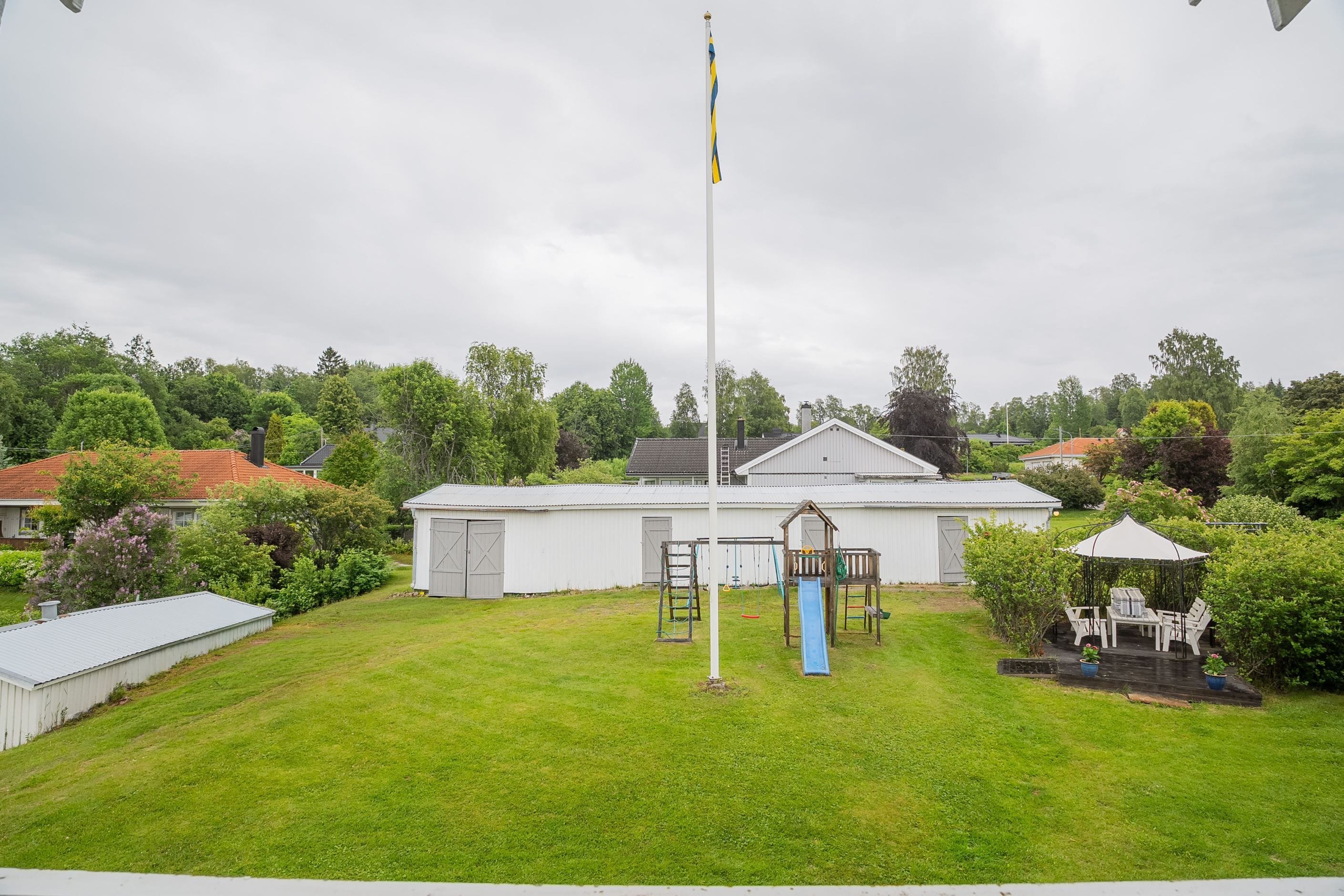 Förrådslängan med lekplats och uteplats
