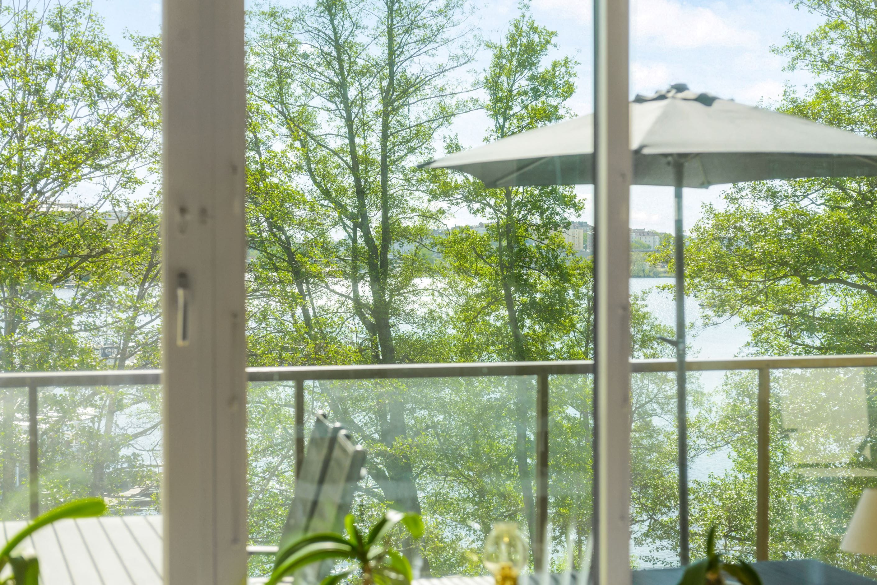 Trivsam inramning av grönska och Mälaren som glittrar i fonden