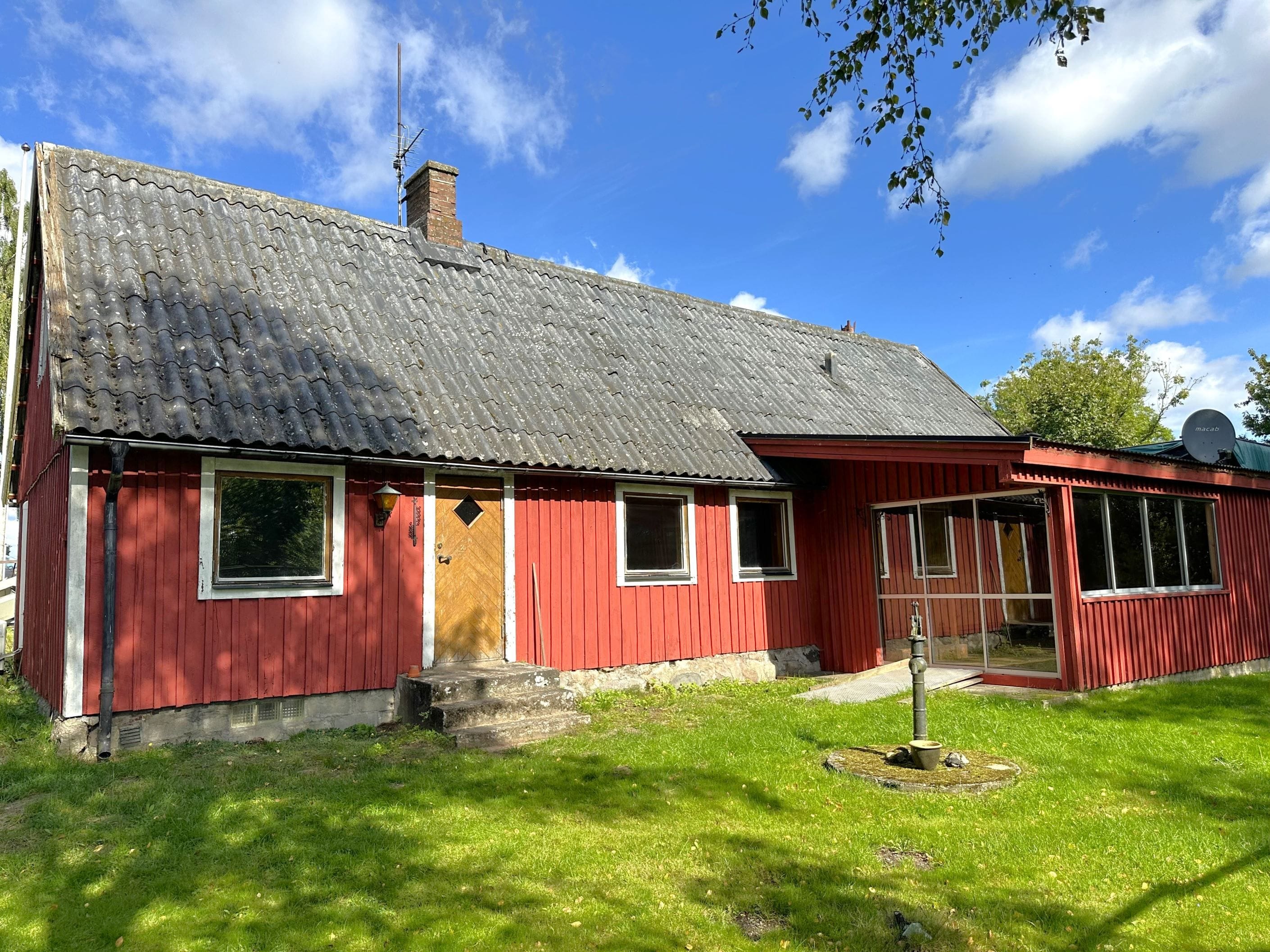 Det röda torpet med vita knutar passar in i den lantliga miljön