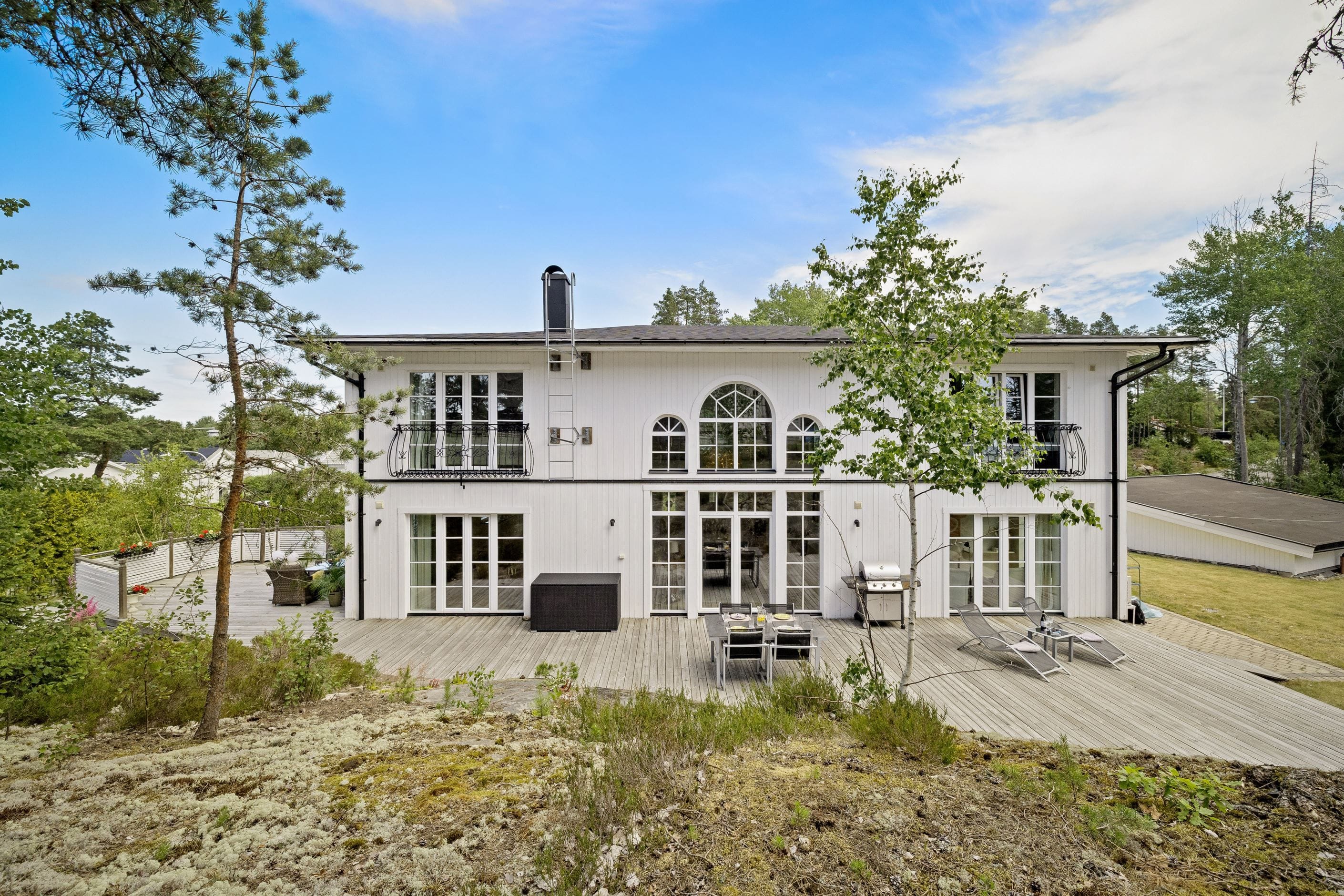 Baksida med stor trädäckad altan