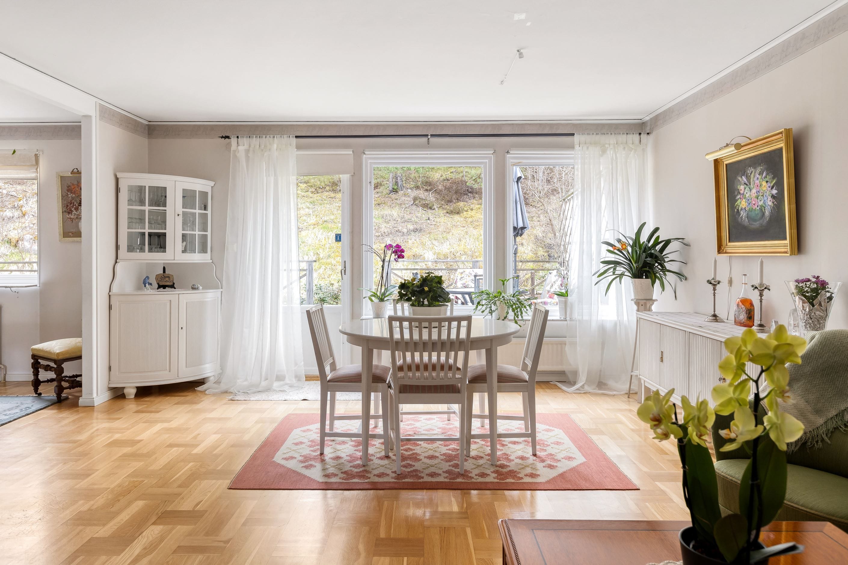 Ljust vardagsrum med vy ut mot närliggande natur