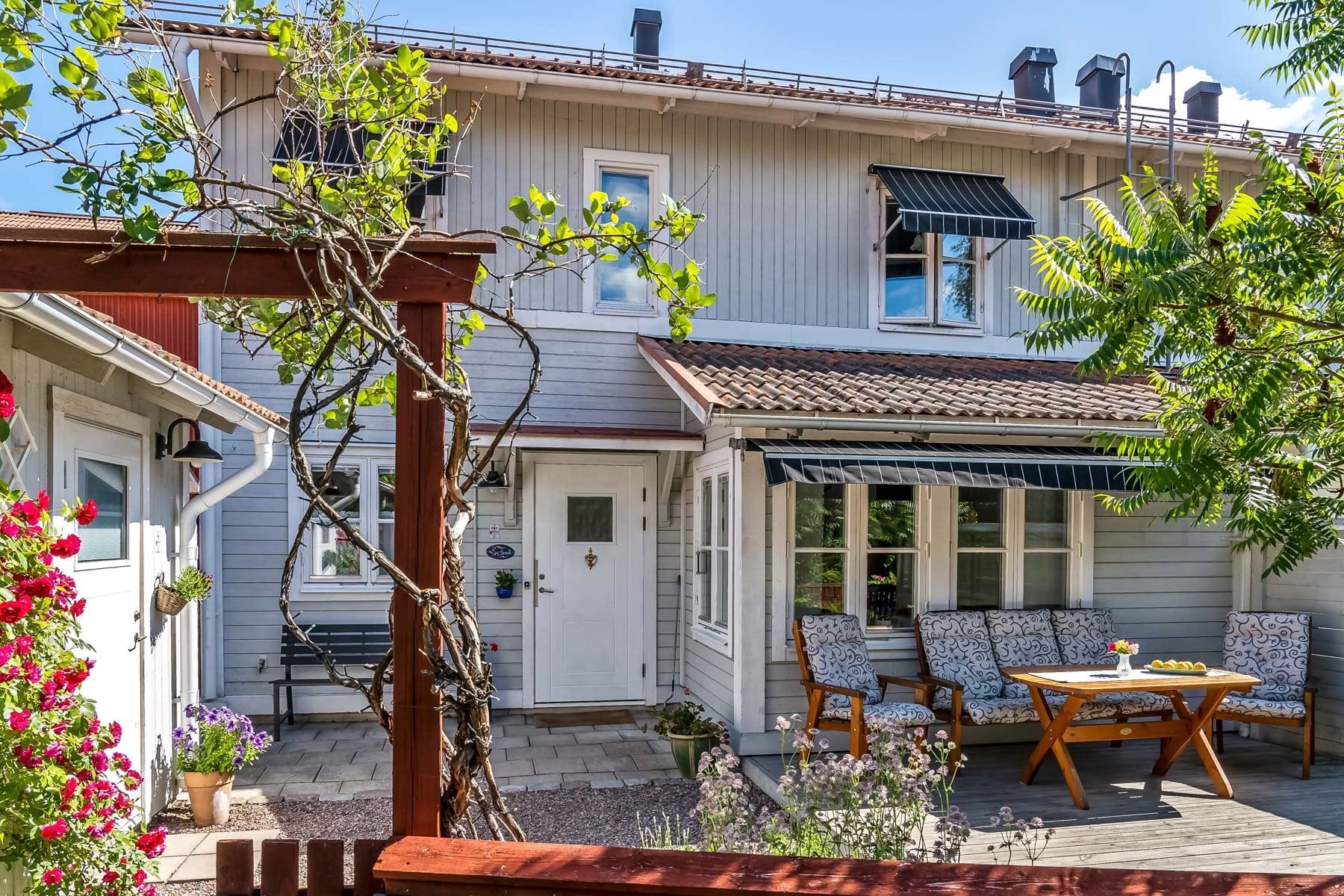 Mysig framsida med uteplats och grönskande trädgård
